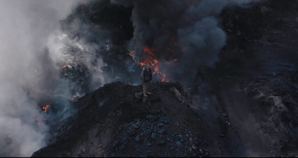 Screen di un corto di Supernature, Who Loves the Sun. Rappresenta un uomo in piedi in una miniera circondato da fiamme e fumo