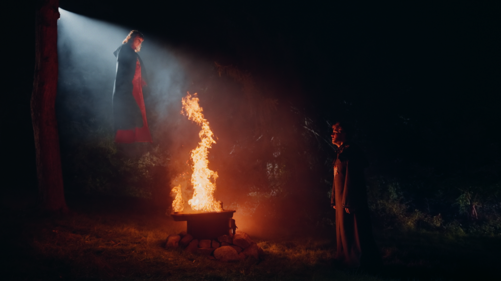 Scena di The Sacrifice, selezionato da ToHorror per Concorto. Raffigura al centro un falò che si staglia nella notte, sulla sinistra una donna, sulla destra un uomo